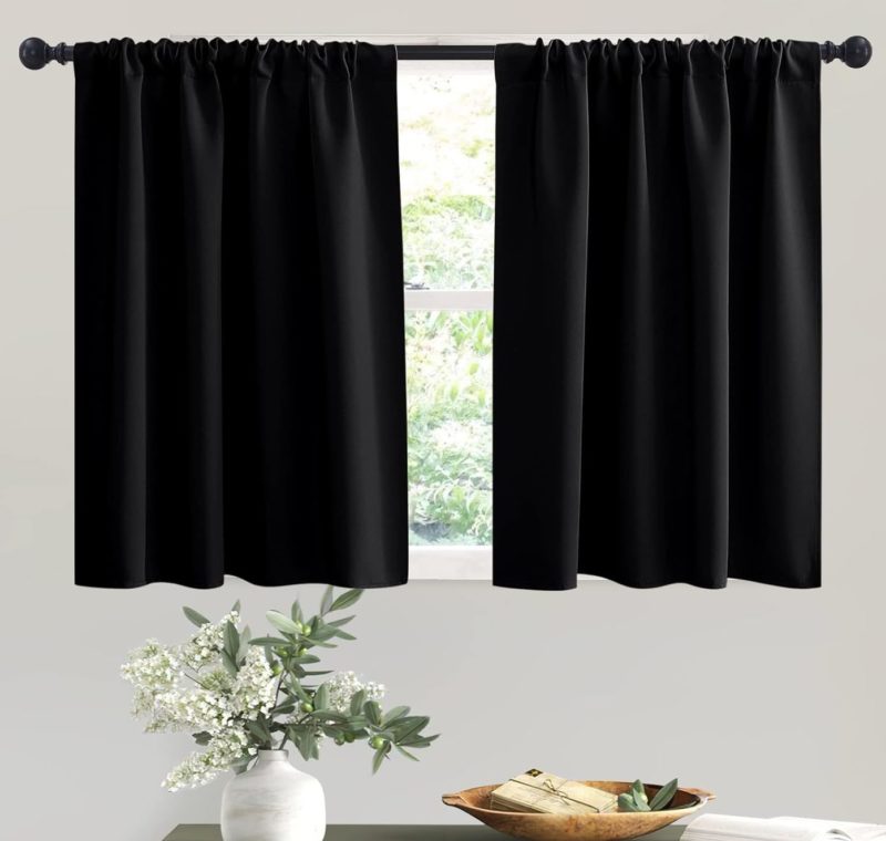 black kitchen curtains hanging on rod behind table